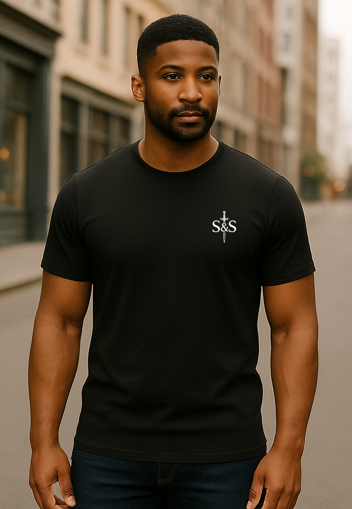 Man wearing a black t-shirt with a logo on a city street